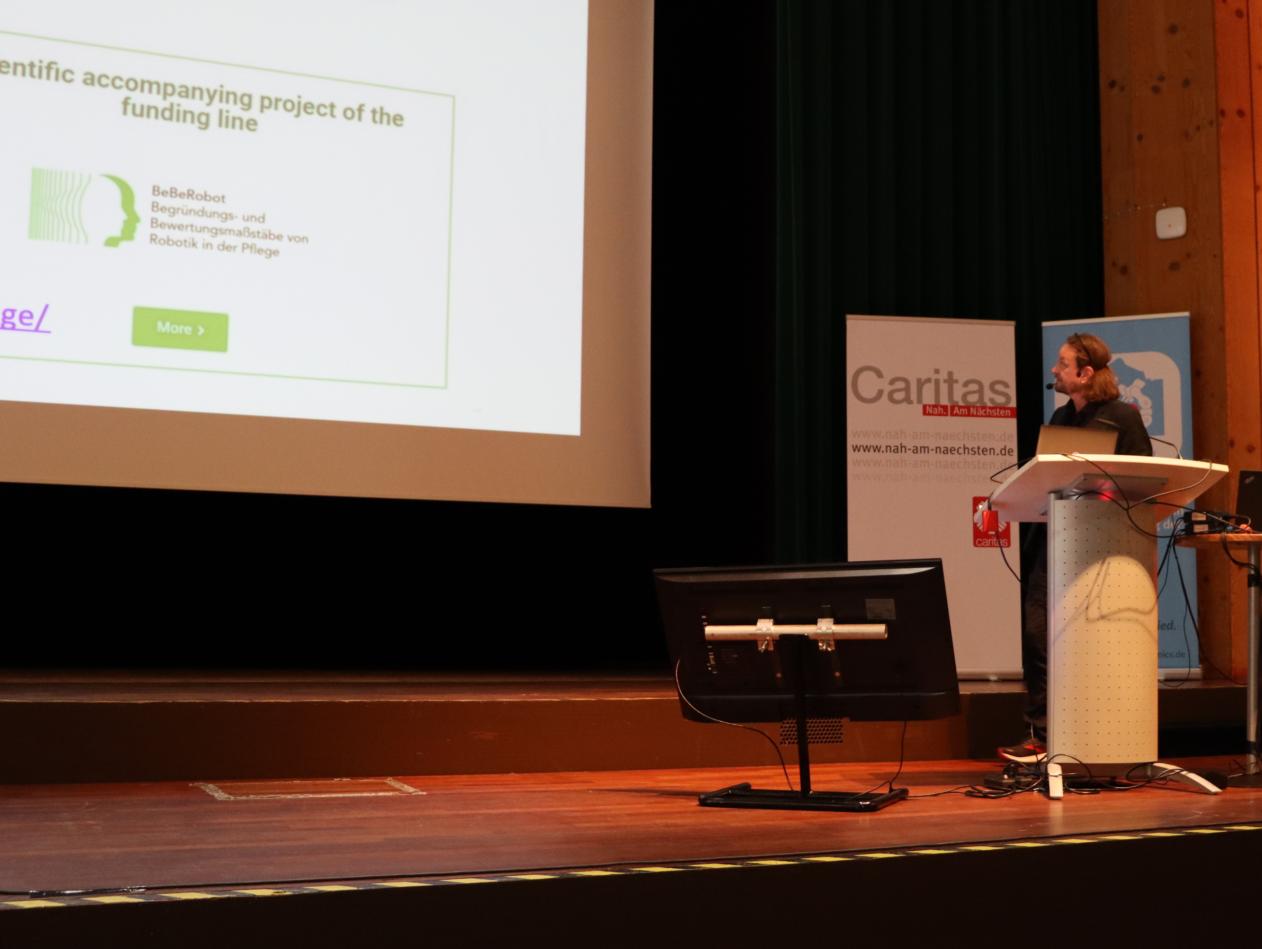 Prof. Dr. Manfred Hülsken-Giesler auf dem Podium während seines Vortrages.